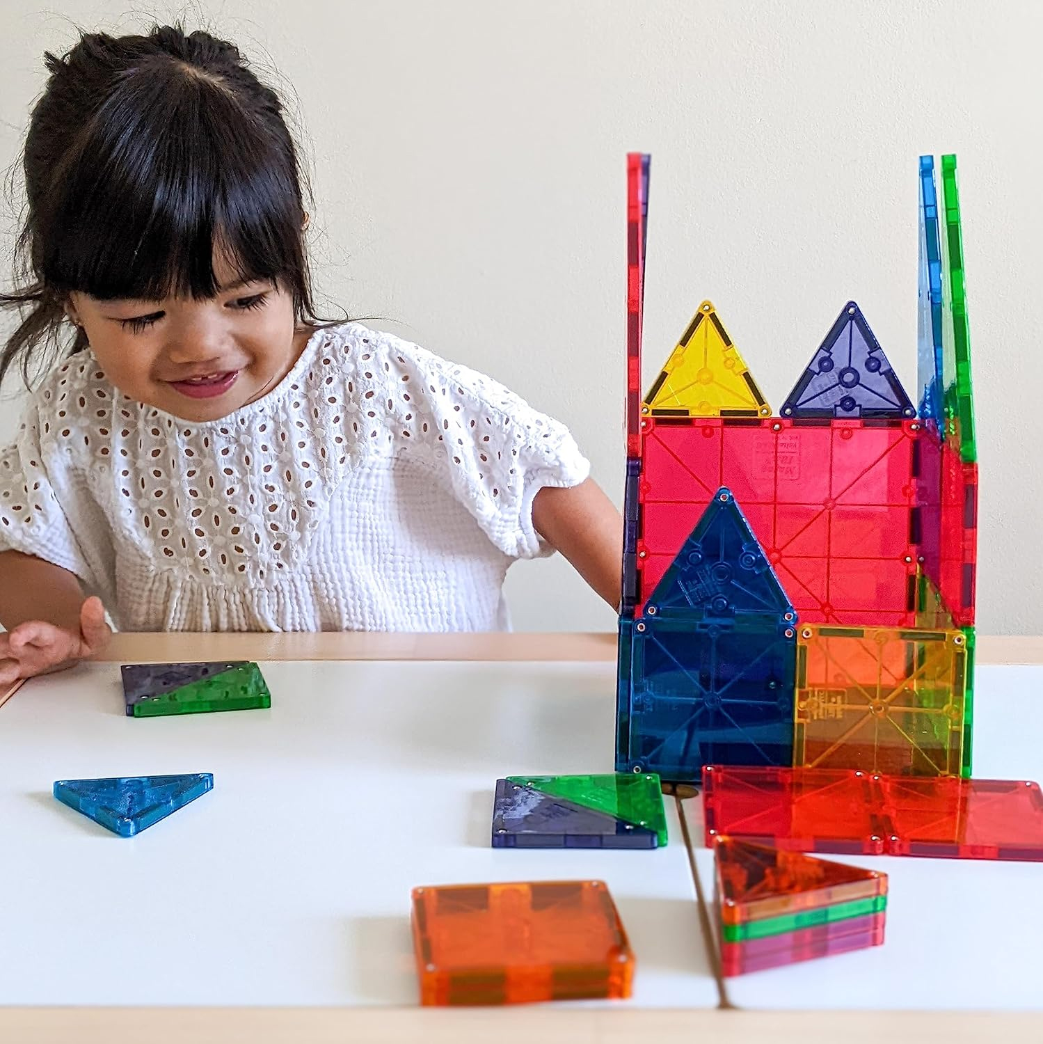 Child playing with MAGNA-TILES Classic 32-Piece and making a toy house using magnetic tiles